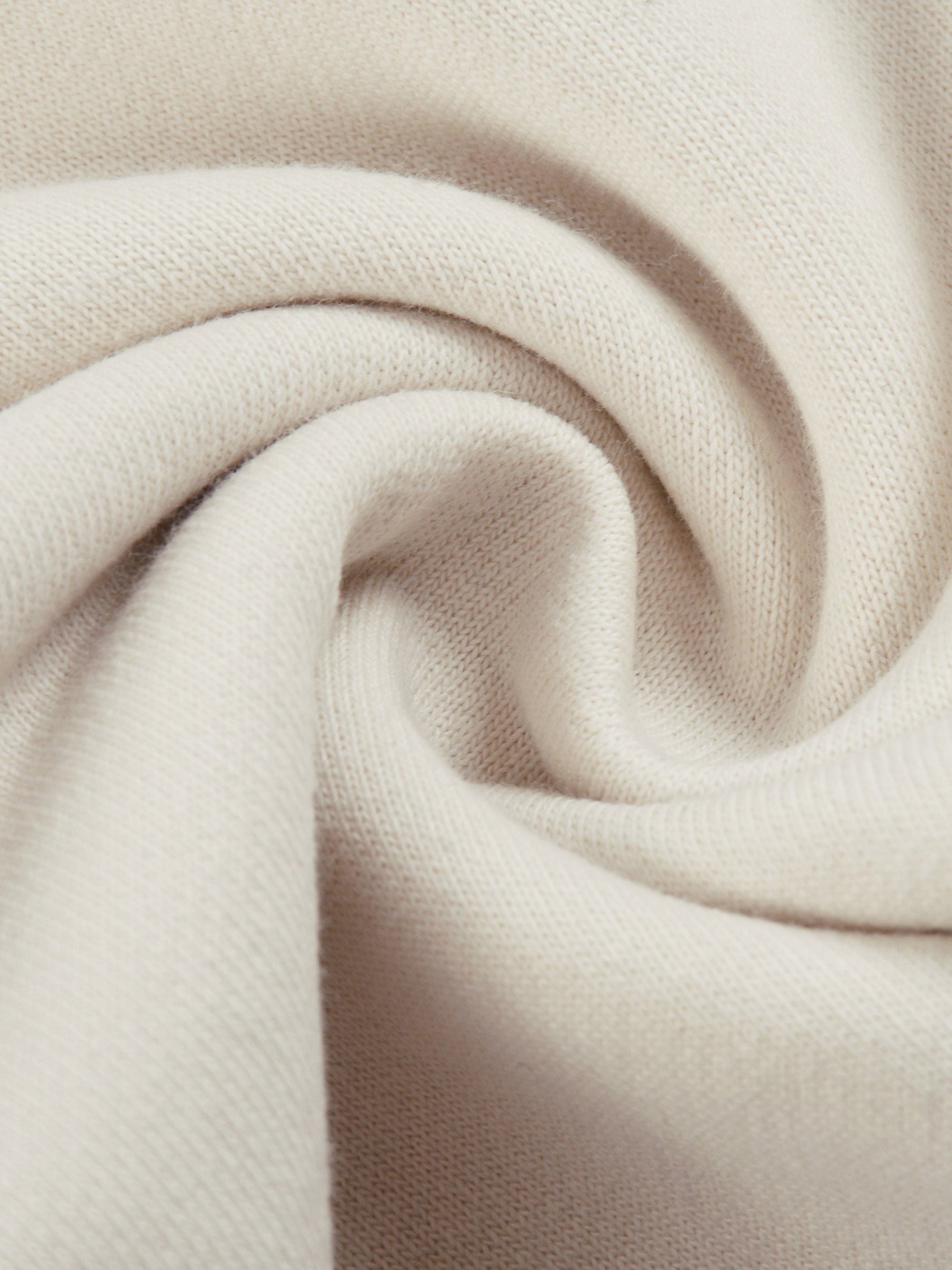 Close-up of beige Genzerz fabric showing soft, premium texture and smooth weave.